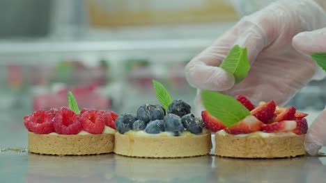 preparación de mini pastel de bayas con hojas de menta
