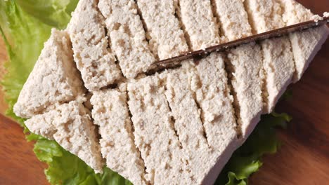 Top-view-of-slice-of-tofu-on-a-chopping-board-on-table-,