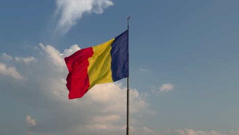 large romanian flag on pole – windy day with dynamic low-angle view