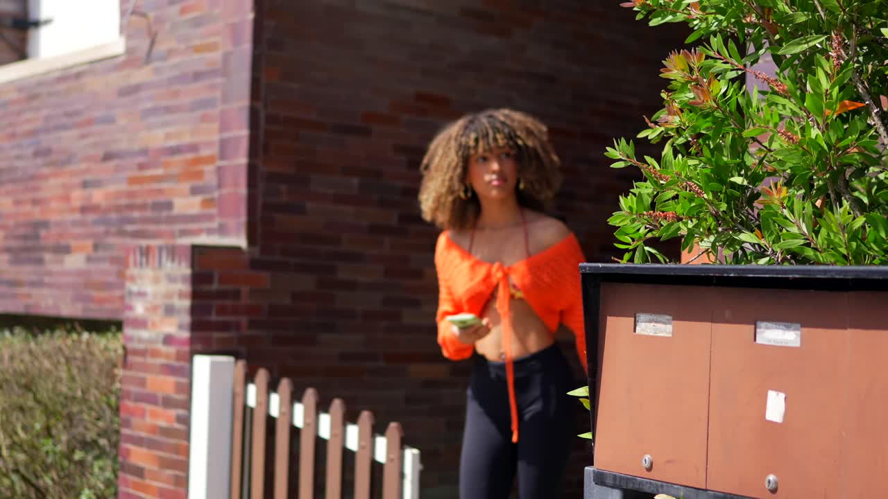 Woman in Orange Sweater on Street
