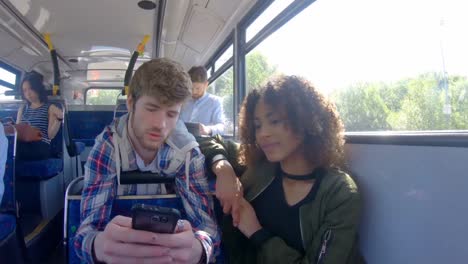 couple using mobile phone on a bus 4k