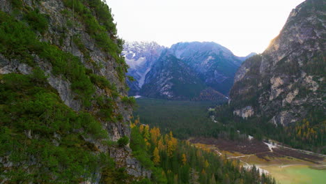 lago di misurina aerial view passing hillside wilderness to reveal alpine woodland valley pass