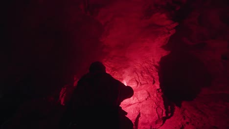 exploración de la cueva por la noche con luces rojas
