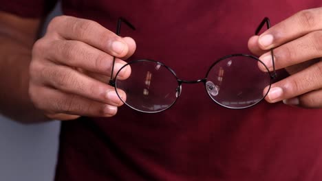 person holding round black eyeglasses