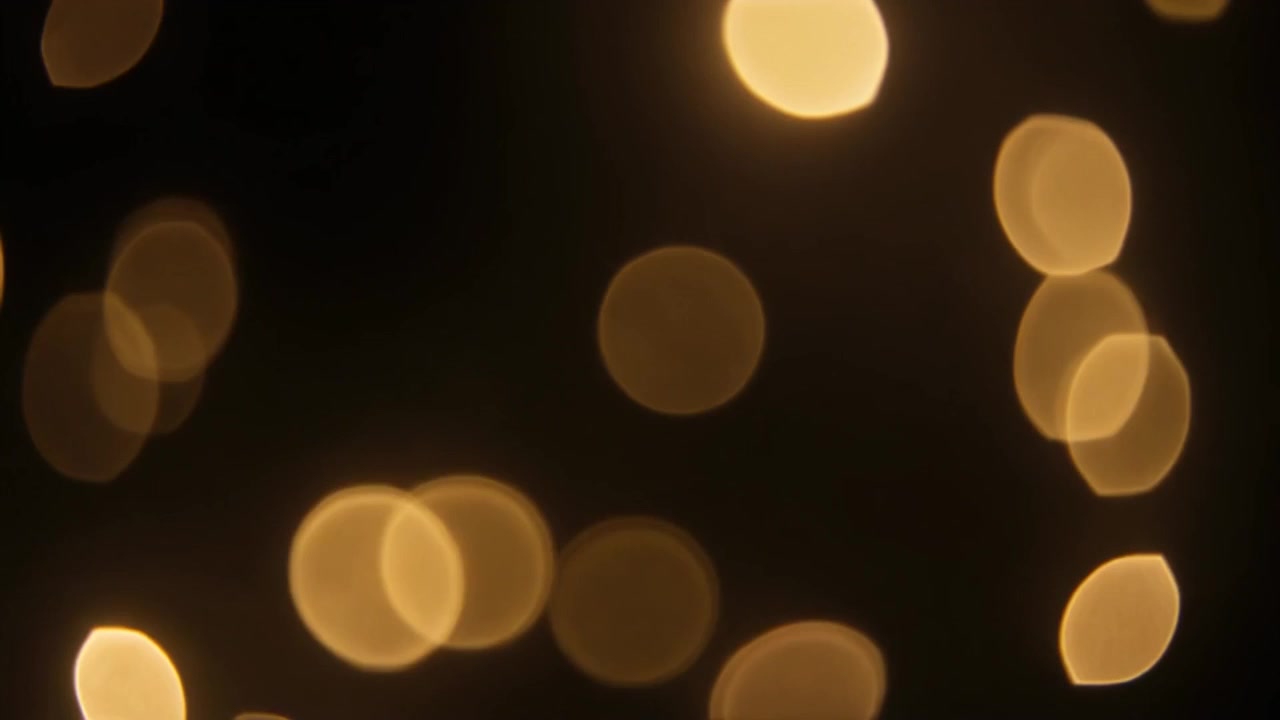 Luci bokeh dorate astratte scintillanti su sfondo nero