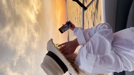 Young-beautiful-woman-taking-selfies-on-a-boat-during-the-sunset-over-the-Adriatic-Sea-near-Dubrovnik,-Croatia