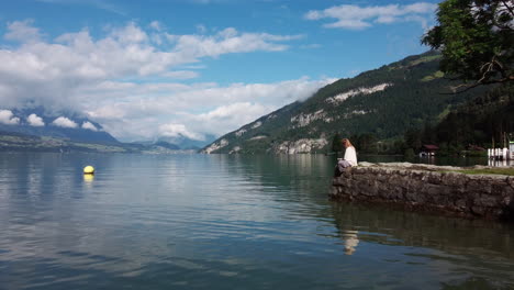 slow flight over lake thunersee near interlaken, showing a young woman enjoying the view