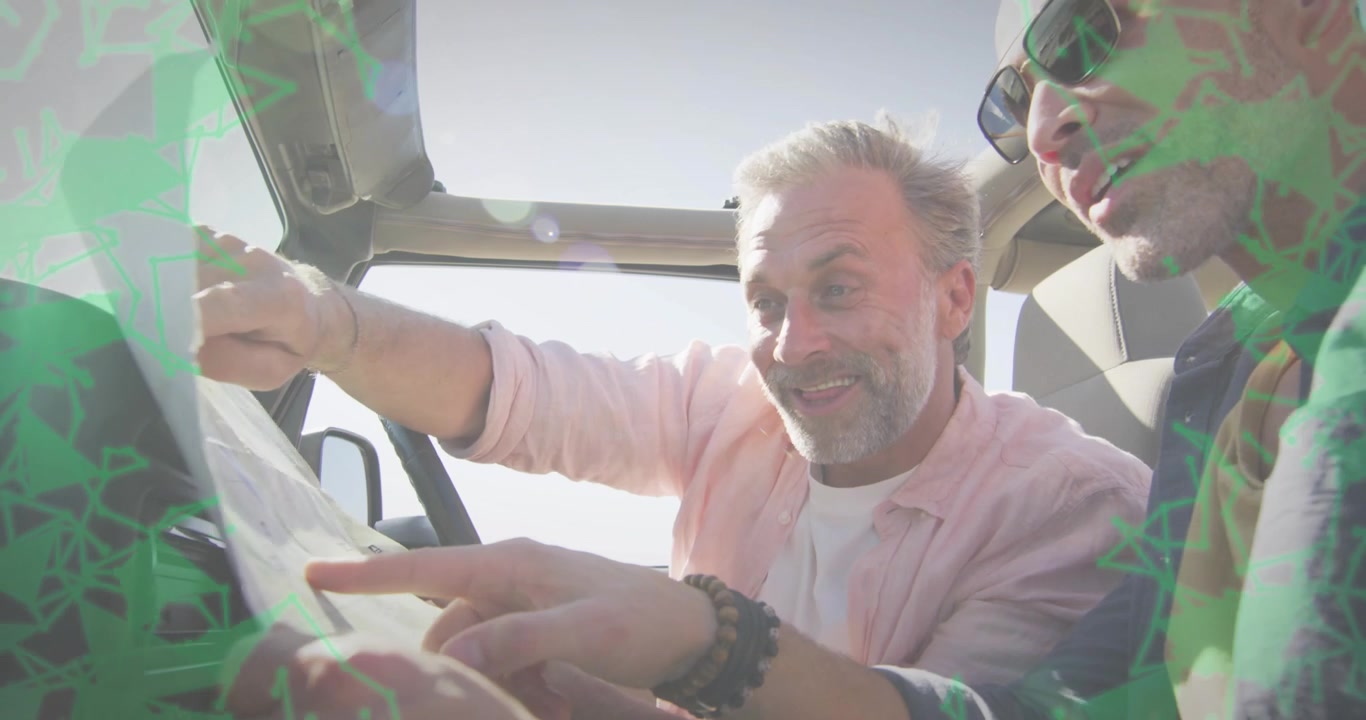 Two mature men unfolding map after parking, pointing and planning travel route across dashboard
