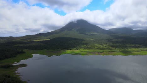 tomada de un avión no tripulado de un volcán masivo en medio de la naturaleza costarricense y al lado de un lago