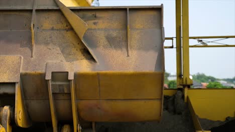 wheel loaders transport aggregate material stock to the cold bin at the asphalt mixing plant factory