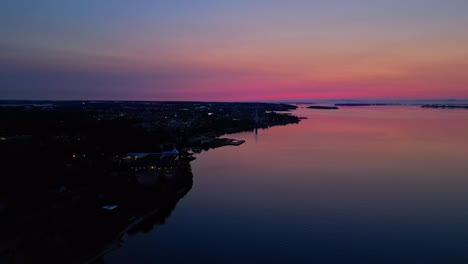 Aerial-of-red-glow-Sunrise-over-a-calm-lake