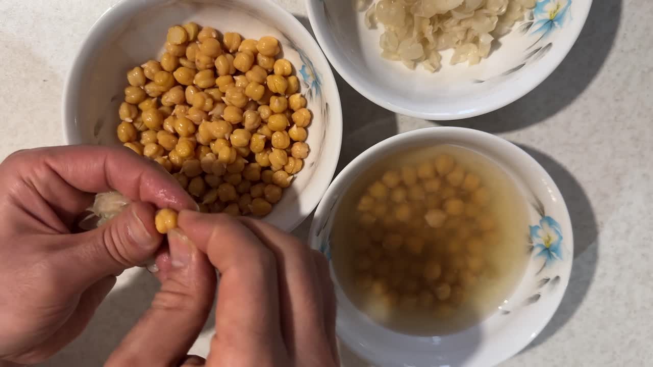 Peeling chickpeas shell skin in cooking hummus appetizer Arabian Mediterranean cuisine style ingredient Mix dip garlic lemon tahini yummy creamy vegan healthy homemade traditional tasty food kitchen