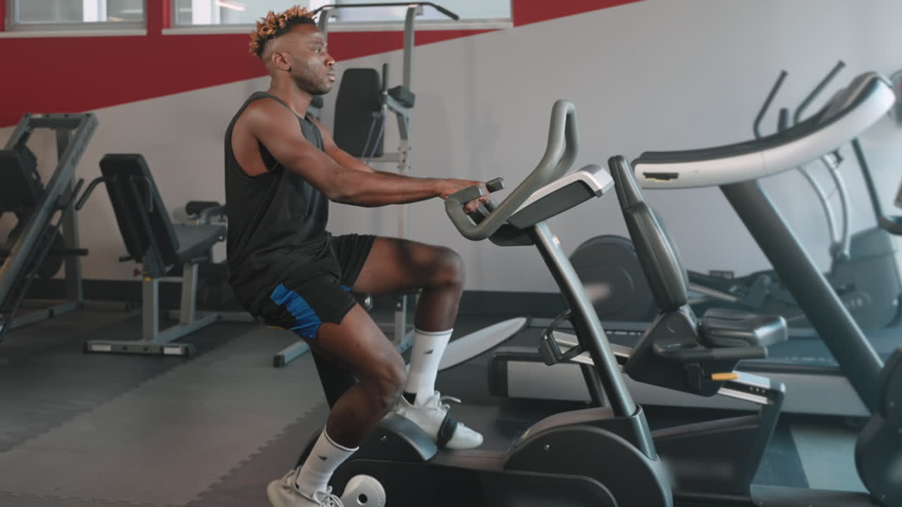 Hombre haciendo ejercicio en una bicicleta estática en un gimnasio