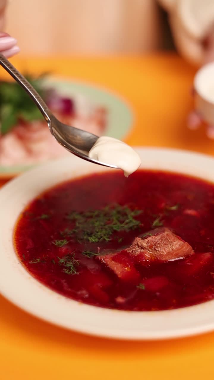 una mujer comiendo sopa de borscht.