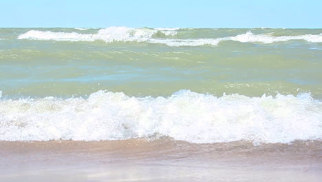 waves crash onto the beach in slo-mo