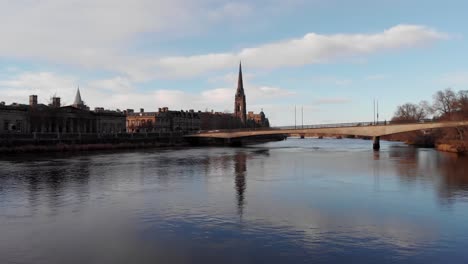 Aerial-low-angle-flyover-the-Tay-River-with-church-and-bridge-of-Perh-in-background