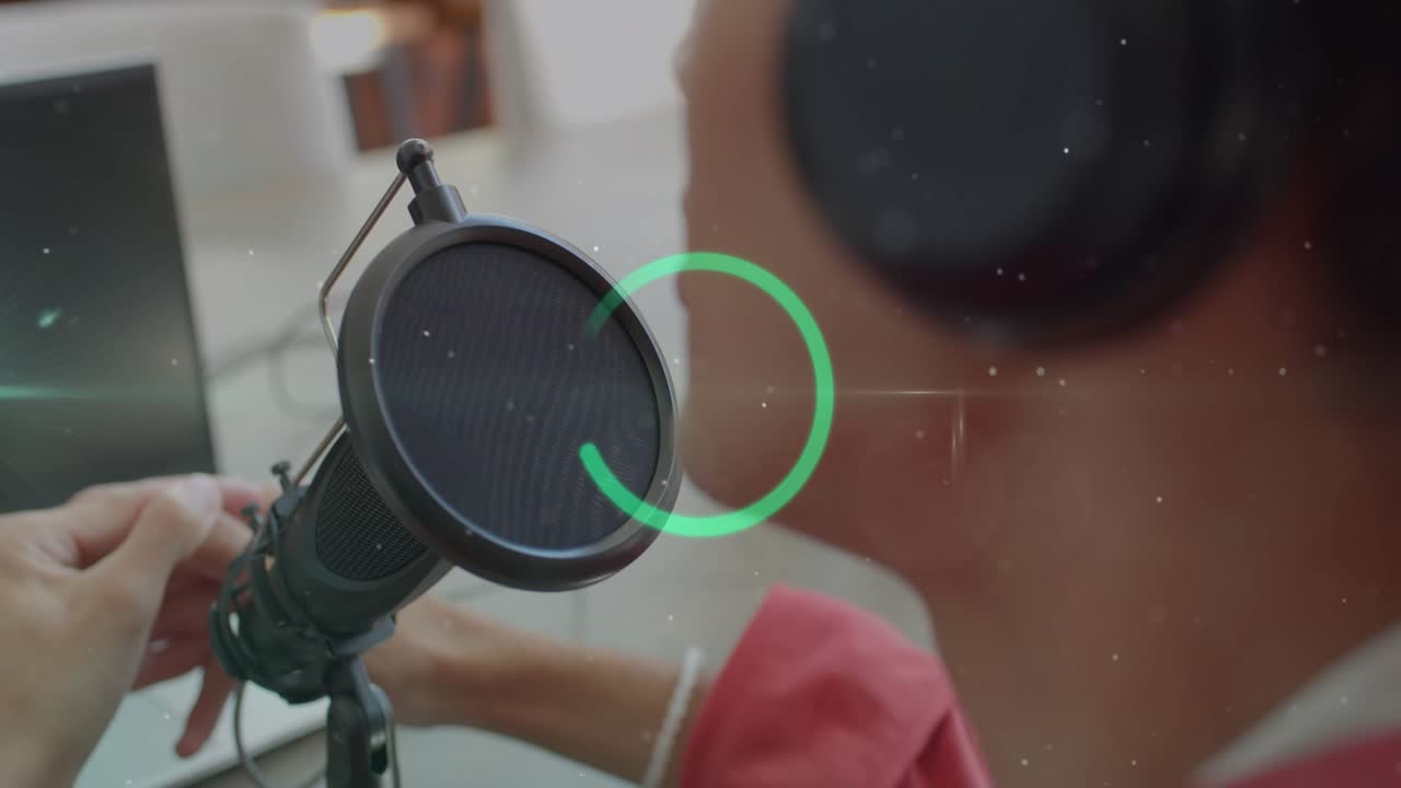 Man adjusting microphone and cable at desk, teal overlay expanding while preparing podcast