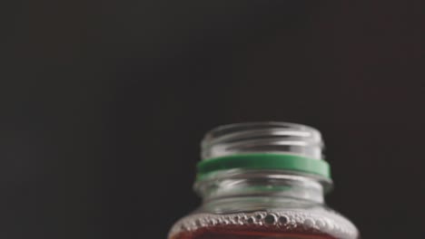 Ein-Mann-öffnet-Den-Verschluss-Einer-Getränkeflasche-Auf-Schwarzem-Hintergrund