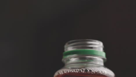 a man opens the cap of a drink bottle on a black background