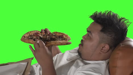 primer plano de un joven con sobrepeso comiendo pizza