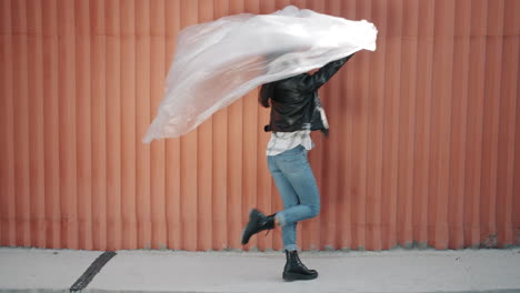 stylish woman dancing with plastic sheet
