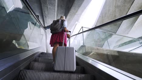 girl riding on escalator in modern terminal