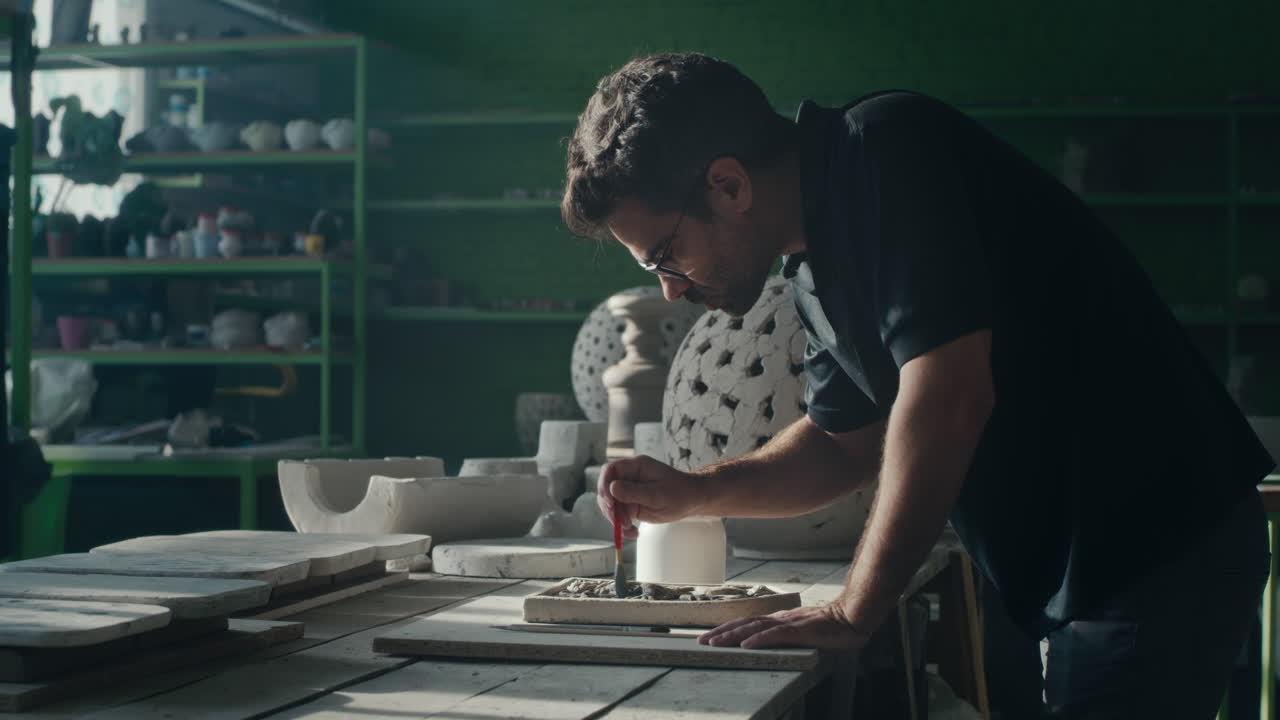 Craftsman working on a ceramic sculpture in a pottery studio