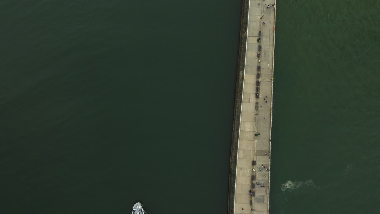 Aerial footage showcasing the pier and coastal maritime activity of Whitby, UK
