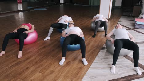 european women are doing renatal exercises with exercise balls and instructor