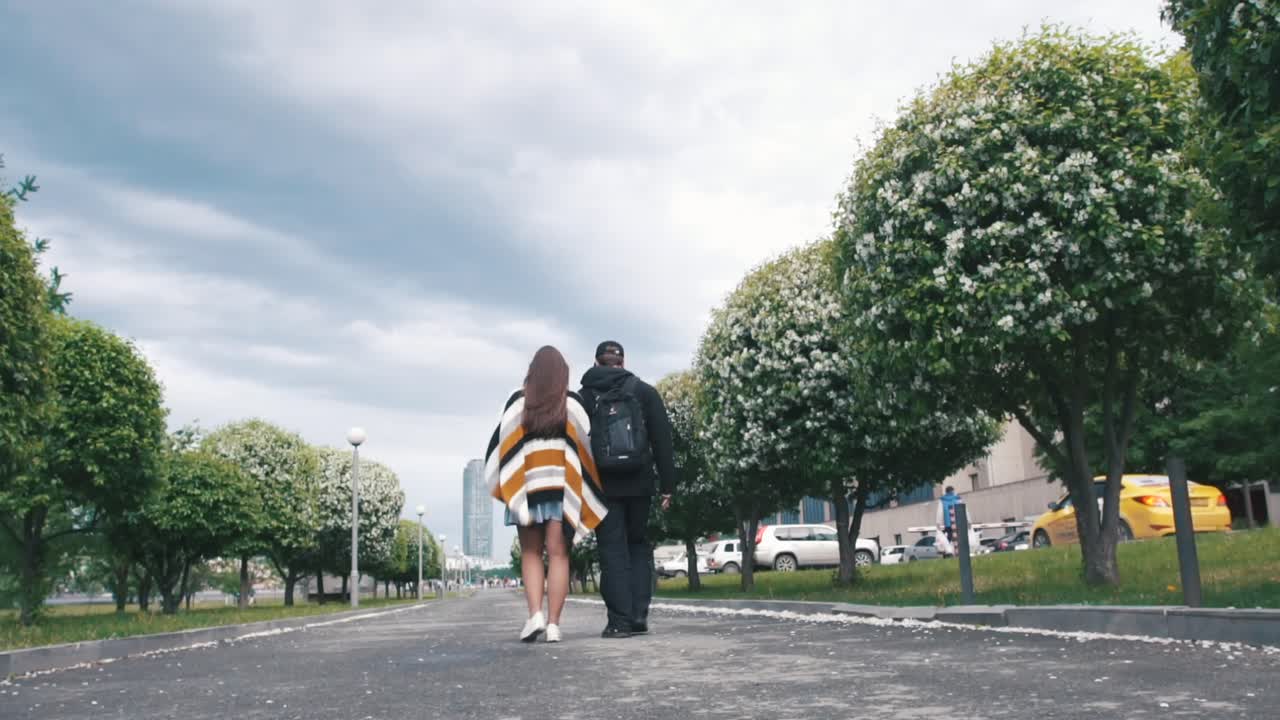 한 커플 이 도시 공원 에서 산책 하고 있다