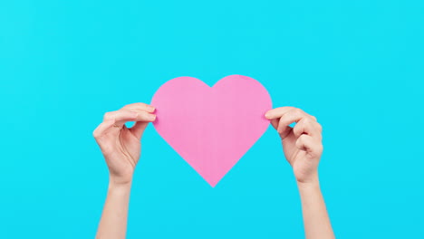fondo azul, espacio y manos con una tarjeta de corazón
