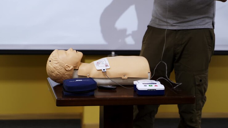 Practical advices for first aid on a mannequin. Trainer demonstrating on a dummy in emergency situation. Training course.