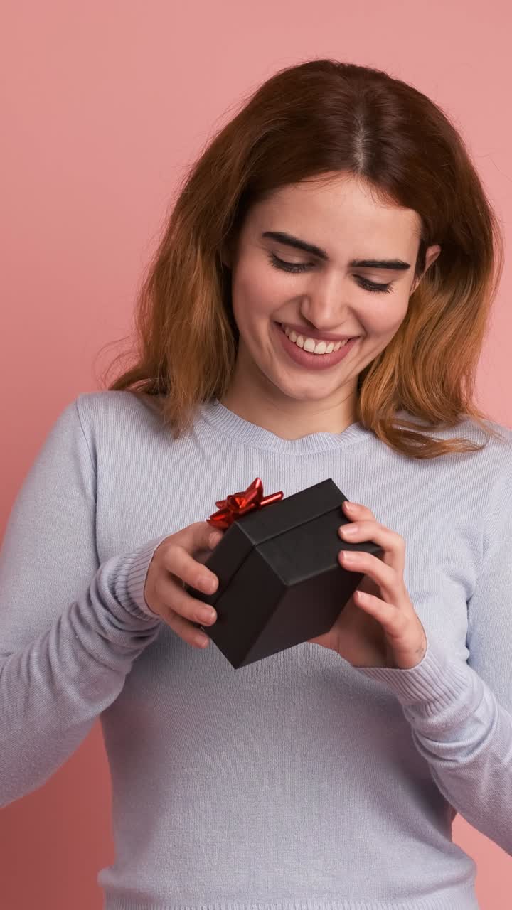 Happy young woman receiving a small gift. Vertical Footage
