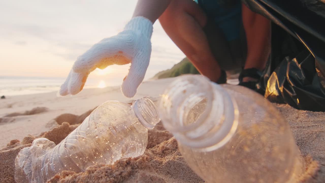 친환경 활동가 여성은 플라스틱 병을 수집하고 쓰레기에서 해변을 청소합니다.