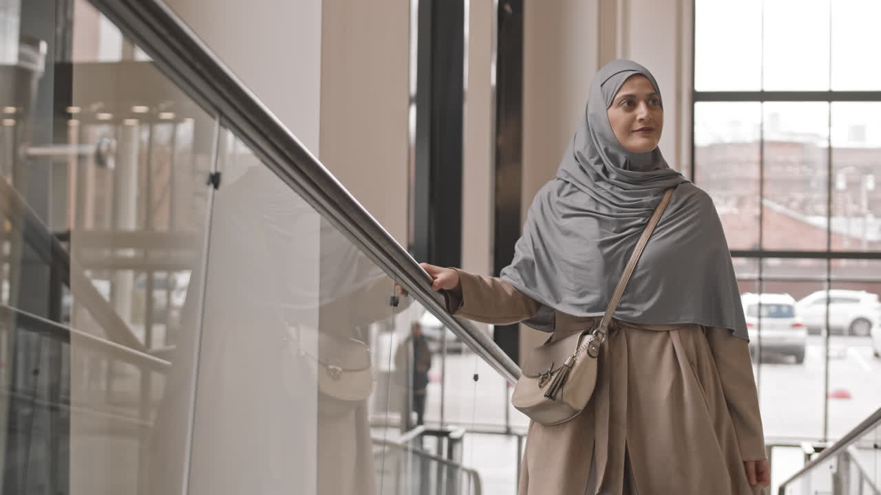 Donna araba su scala mobile in ufficio