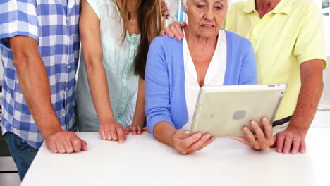 familia feliz mirando tableta juntos