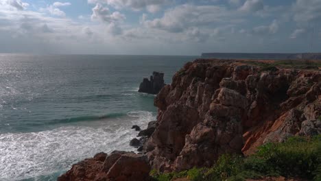 Die-Unglaubliche-Landschaft-Eines-Strandes,-Mit-Den-Schäumenden-Weißen-Wellen,-Die-Sich-Auf-Dem-Weißen-Sand-Brechen,-Umgeben-Von-Klippen