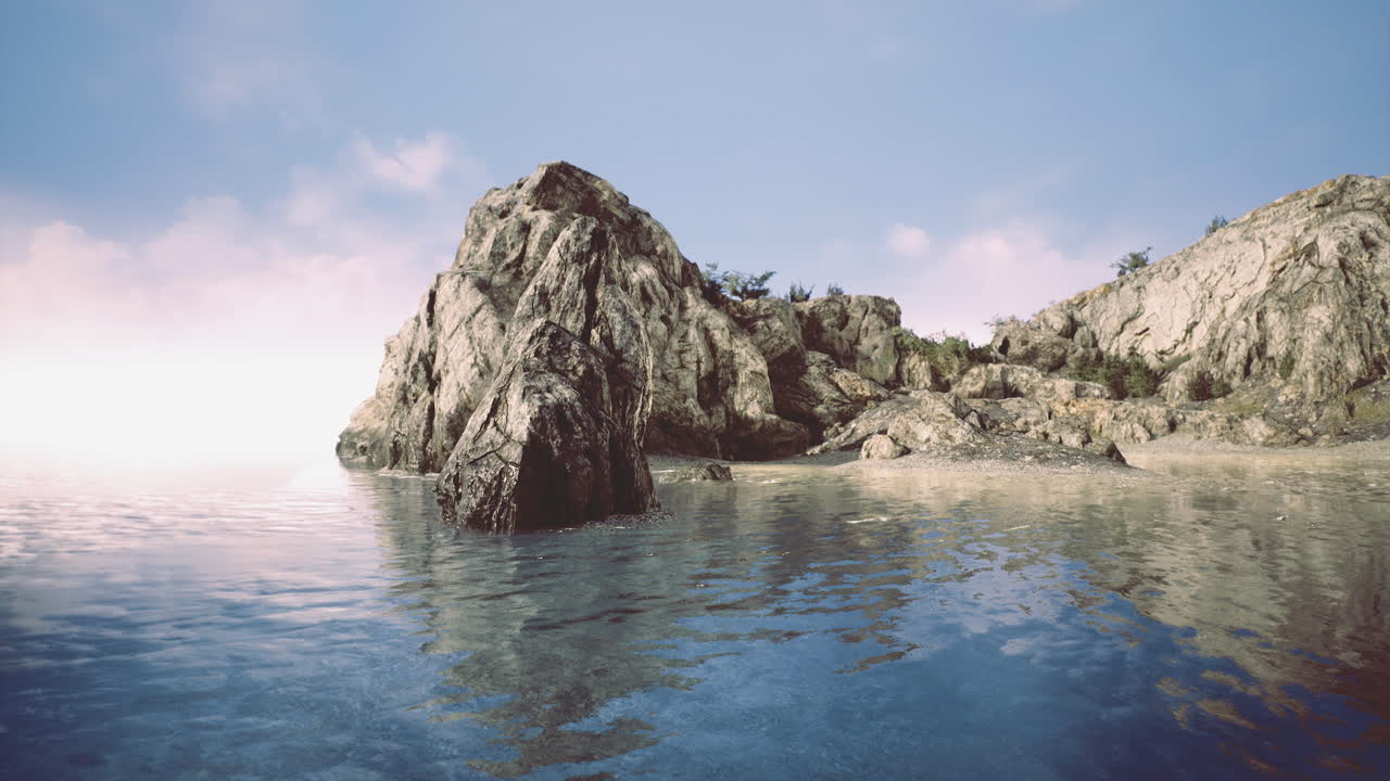 Serene rocky coastline with calm waters reflecting a blue sky