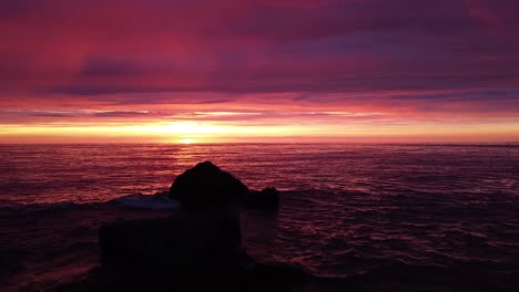 beautiful aerial vibrant high contrast pink purple sunset over baltic sea, karosta war port concrete coast fortification ruins at liepaja, wide angle drone shot moving forward over the calm sea