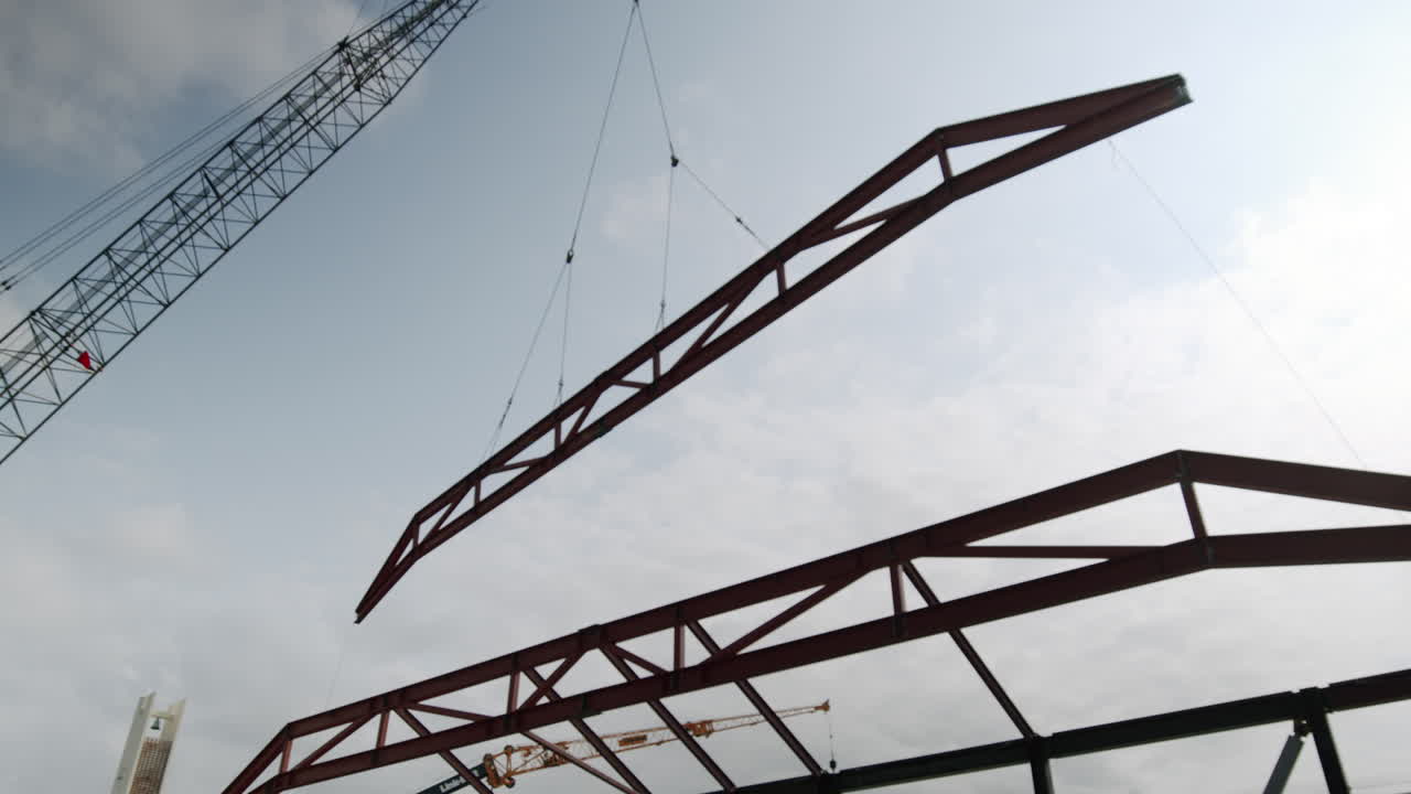 Crane Lifting a Metal Truss for Building Construction
