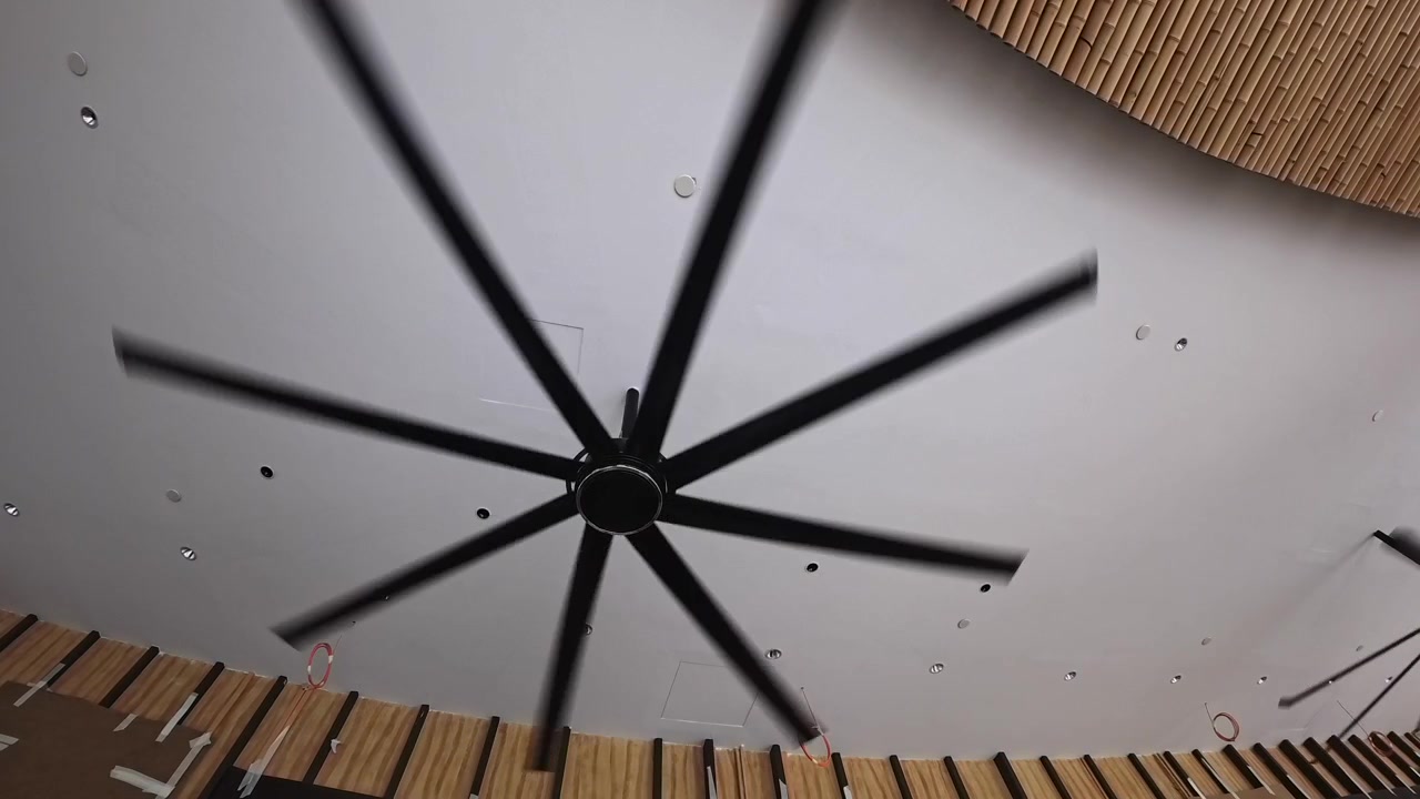 Grande ventilatore da soffitto industriale in rotazione all'interno di un edificio moderno