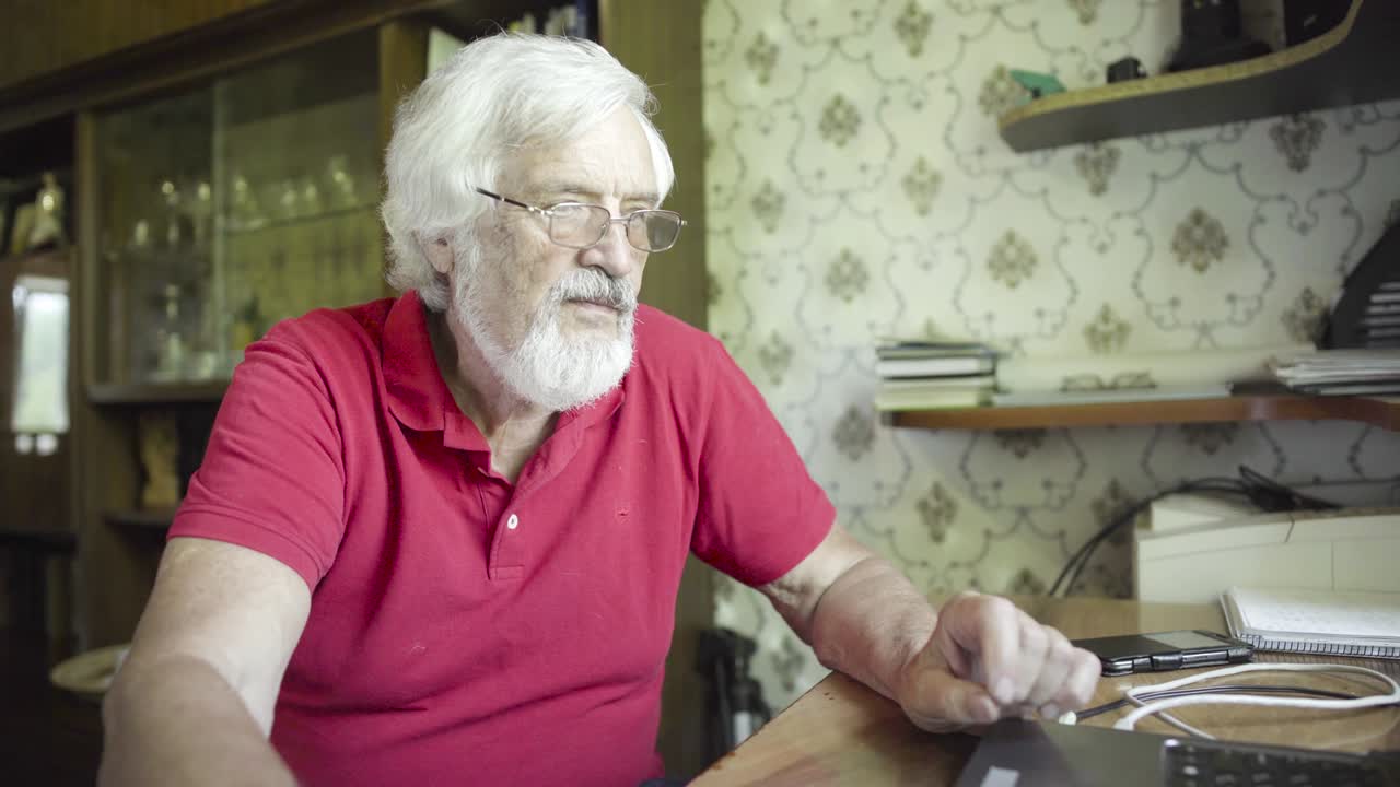 hombre mayor usando una computadora portátil en casa