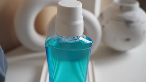 mouthwash bottle on white table with decorative objects