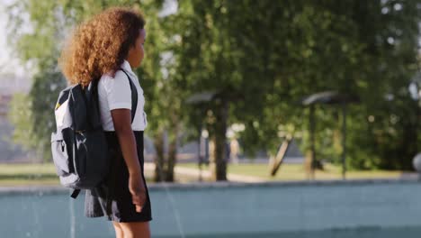 schoolgirl walking near a fountain
