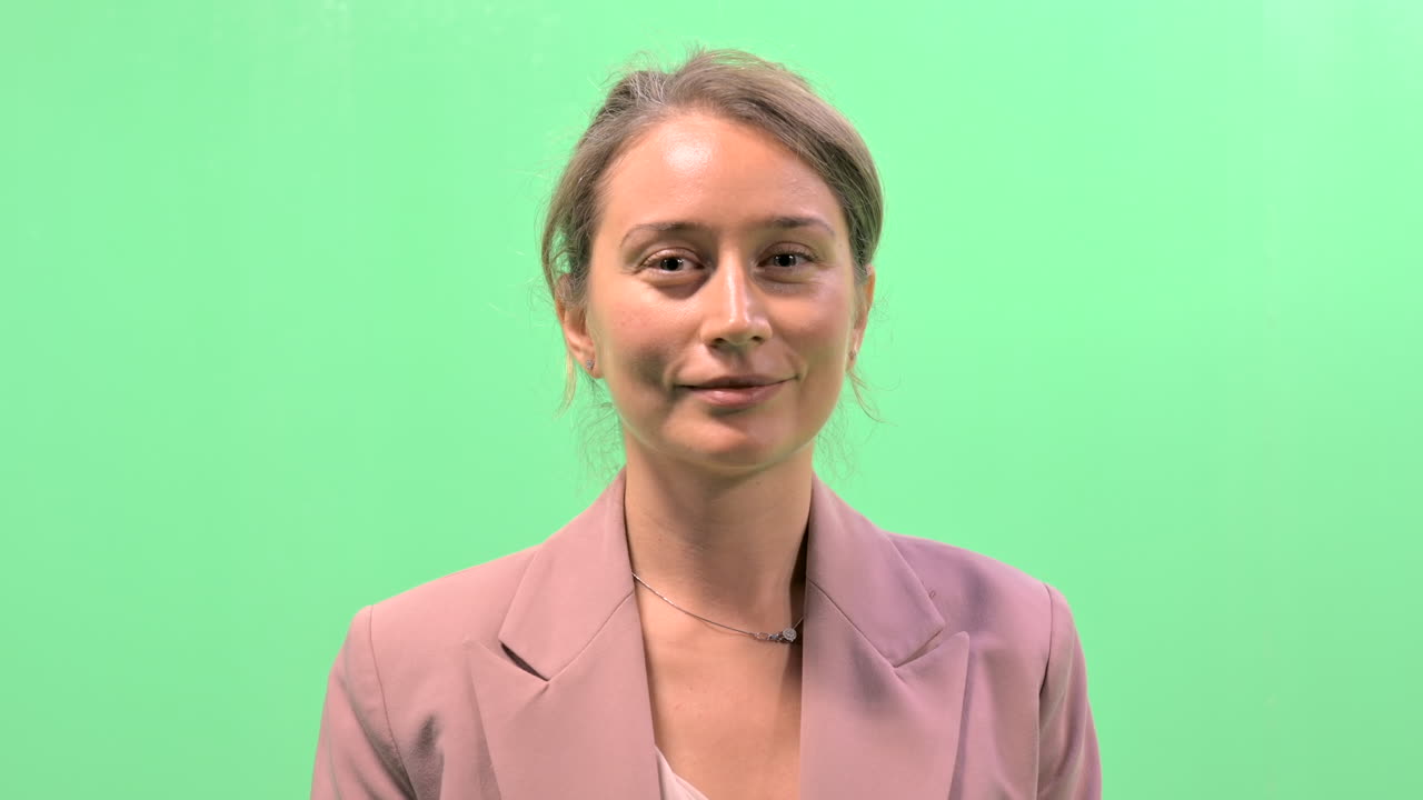 Woman making funny faces in front of a green screen