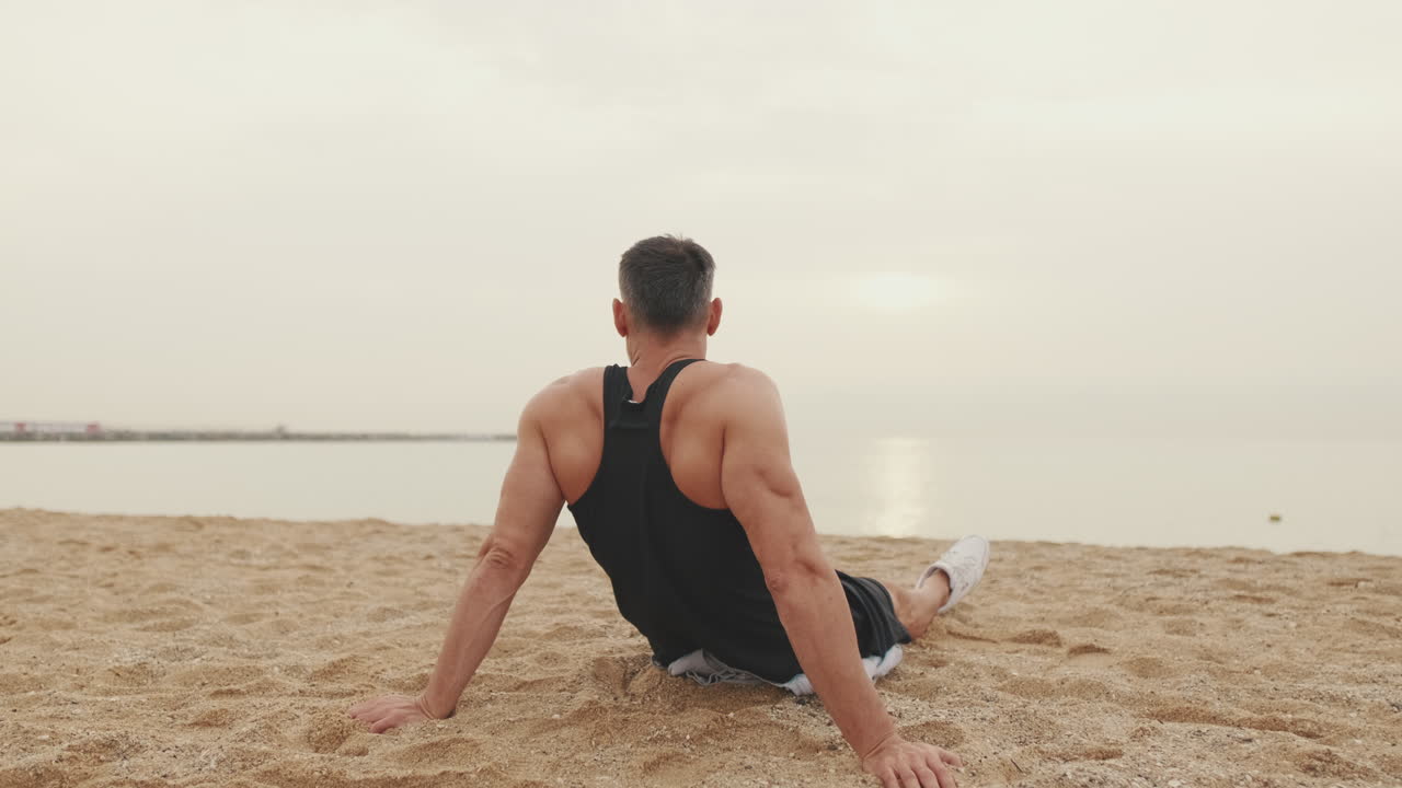 Man resting on the beach after workout