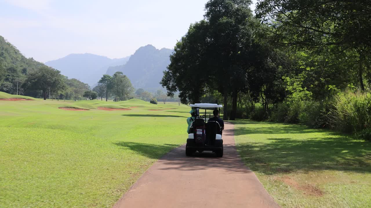 골프 카트 가 경치 좋은 골프 코스 경로 를 따라 운전 하고 있다