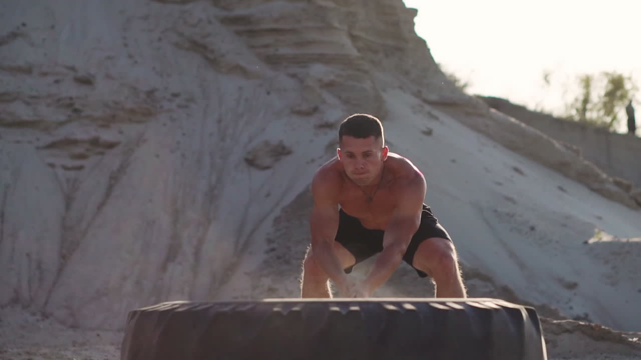 hombre de fitness deportivo golpeando el neumático de la rueda con el trineo de martillo entrenamiento de ajuste cruzado,