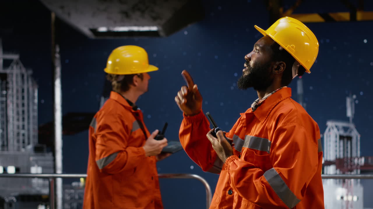 Worker on maritime oil rig uses radio communication for drilling operations