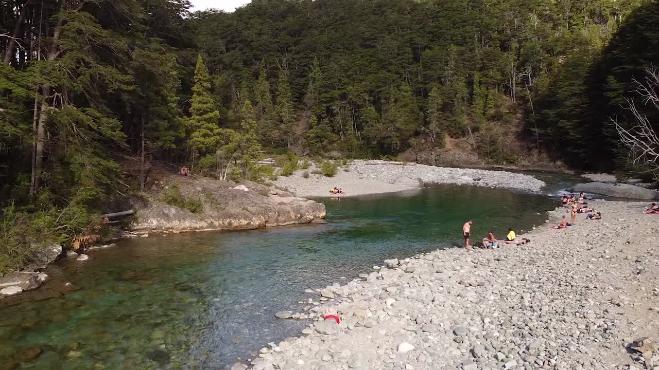 River in one with trees and vegetation and stony ground